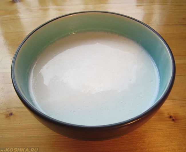 Белое молоко в коричневой миске на столе