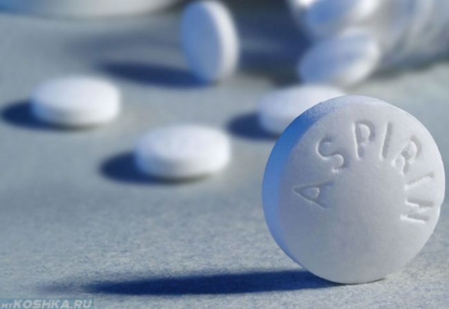 Белые таблетки аспирина на столе