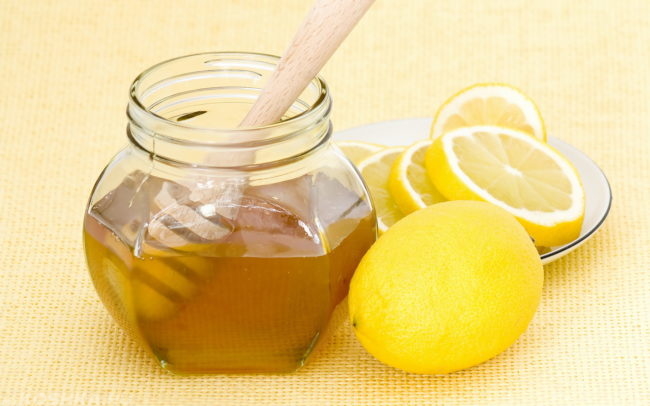 Банка мёда и нарезанный лимон на блюдце