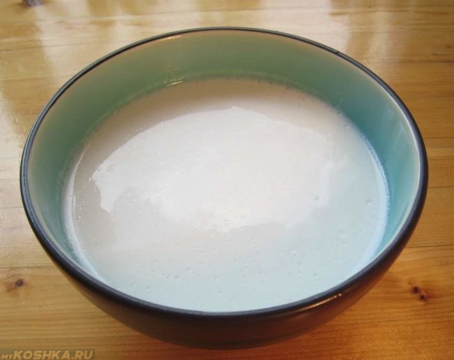 Молоко в миске на деревянном столе